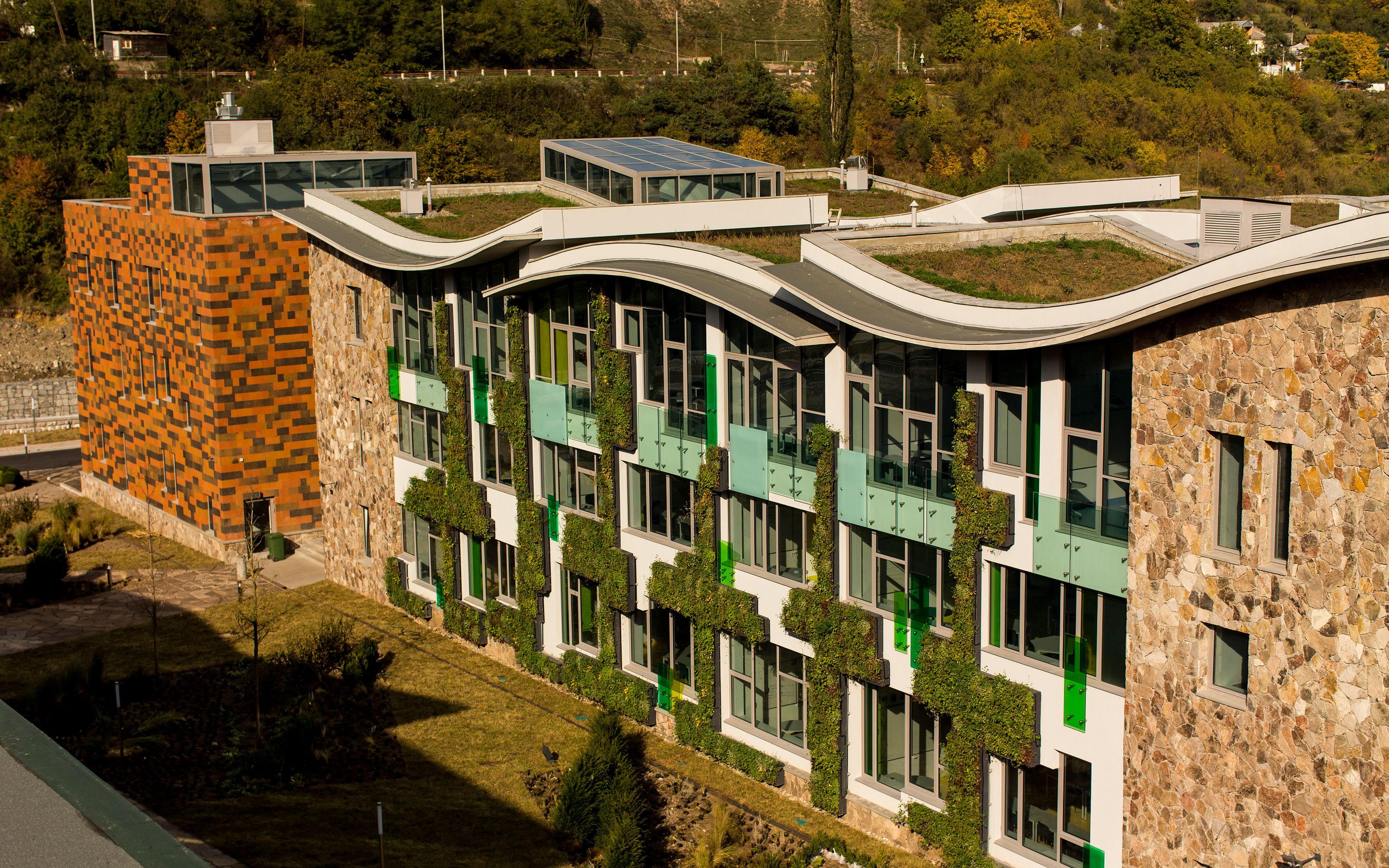 Vegetated facades and curved green roof areas on a large building